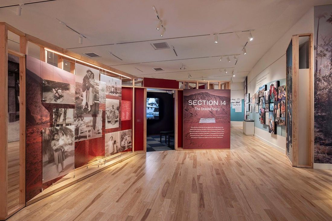 A gallery of wood-framed panels hung with large black-and-white family photographs leads to a red wall titled Section 14: The Untold Story.